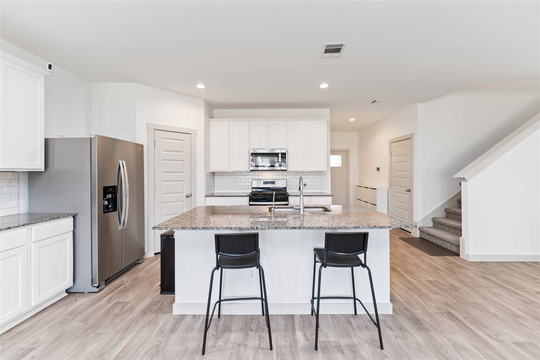 10610 Kings River Drive Rosharon, TX 77583 - Photo 5 of 33 a kitchen with stainless steel appliances a dining table chairs microwave and refrigerator