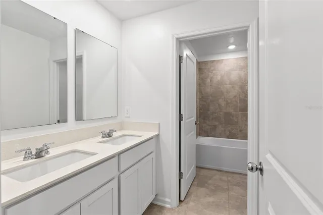 a bathroom with a tub sink shower and a mirror