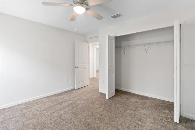 an empty room with a ceiling fan and a window