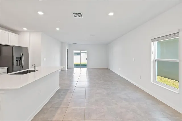 a view of a hallway to an empty room and window