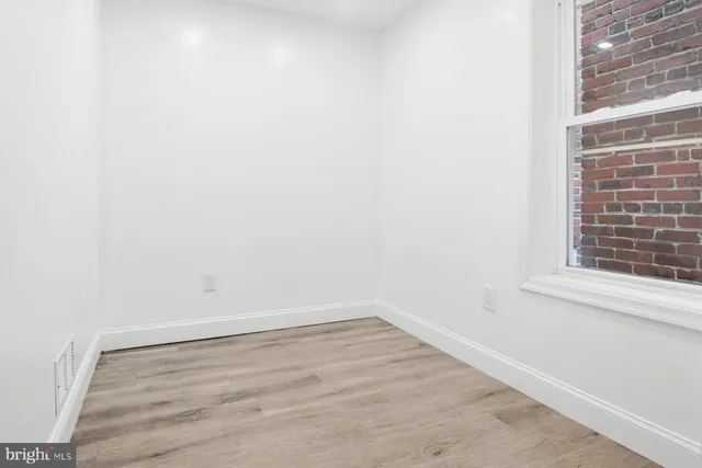 a view of a small space with wooden floor and a window