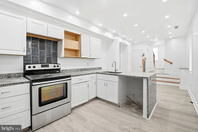 a kitchen with a sink stove and cabinets