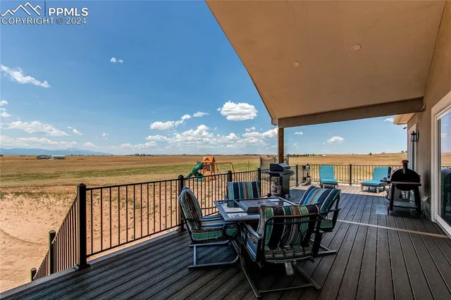 a view of a balcony with furniture and wooden floor