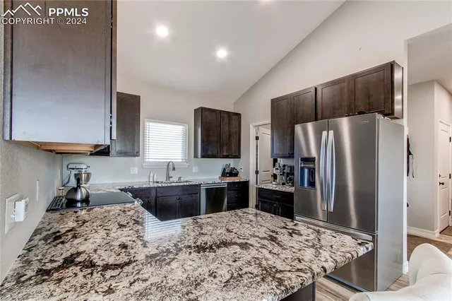 a kitchen with a refrigerator sink and stainless steel appliances