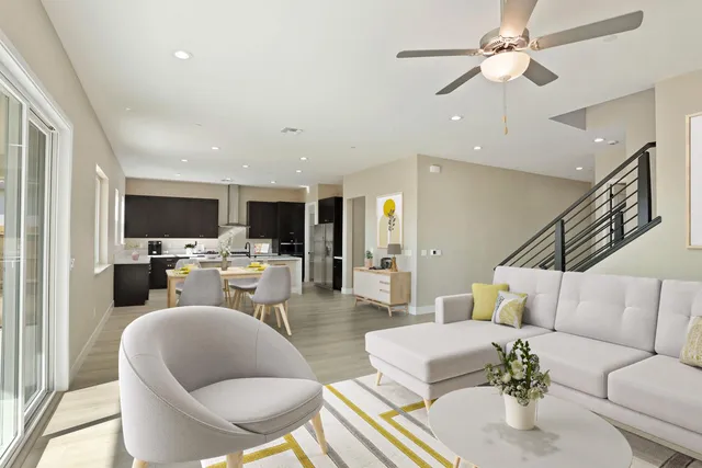a living room with furniture kitchen view and a flat screen tv