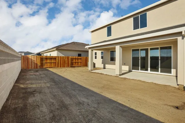 a view of a patio with couches table and chairs with plants and garden
