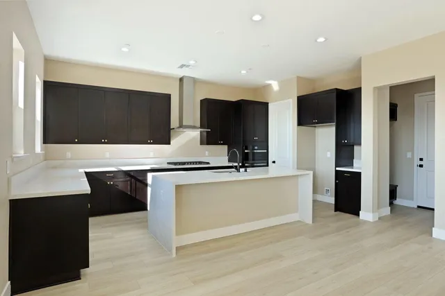 a kitchen with kitchen island granite countertop a sink cabinets and stainless steel appliances