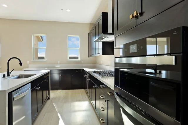 a kitchen with stainless steel appliances granite countertop a sink and a stove