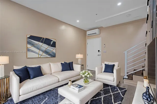 a living room with furniture and a painting on the wall