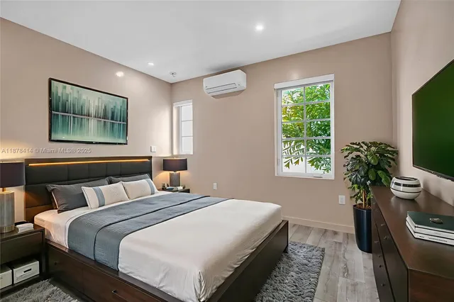 a bedroom with bed and a potted plant