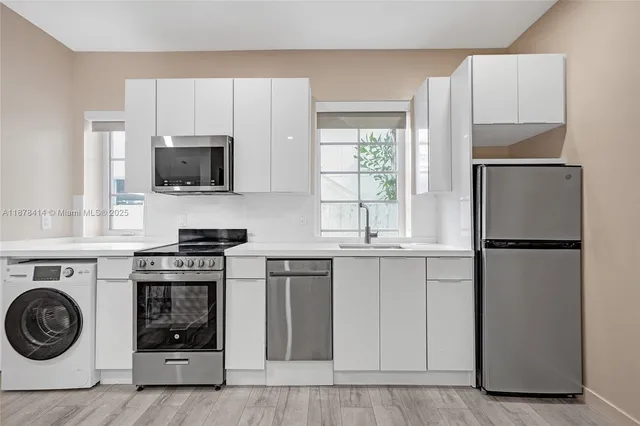 a kitchen with a stove a sink and a refrigerator
