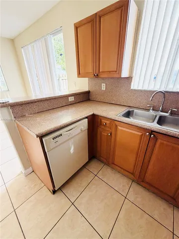 a kitchen with a sink cabinets and window