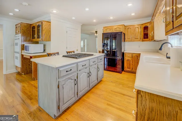 a living room with stainless steel appliances kitchen island granite countertop furniture and a wooden floor