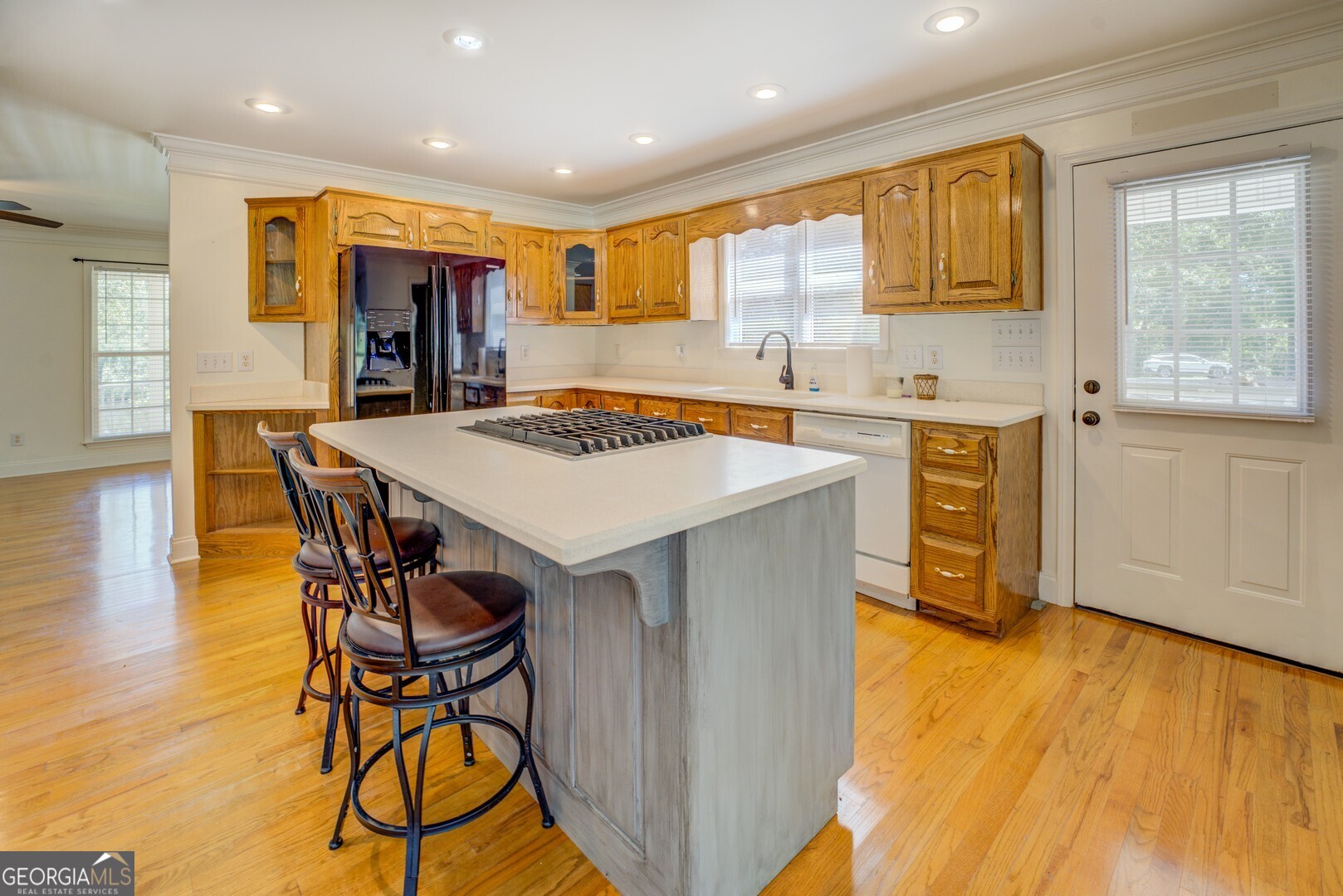 925 Highway 36 East Jackson, GA 30233 - Photo 19 of 90 a kitchen with stainless steel appliances kitchen island granite countertop a stove a refrigerator a sink a dining table and chairs with wooden floor