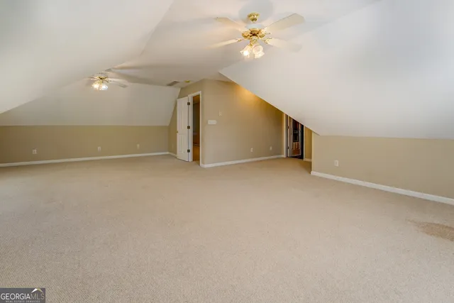 a view of a lake with a yard and large trees