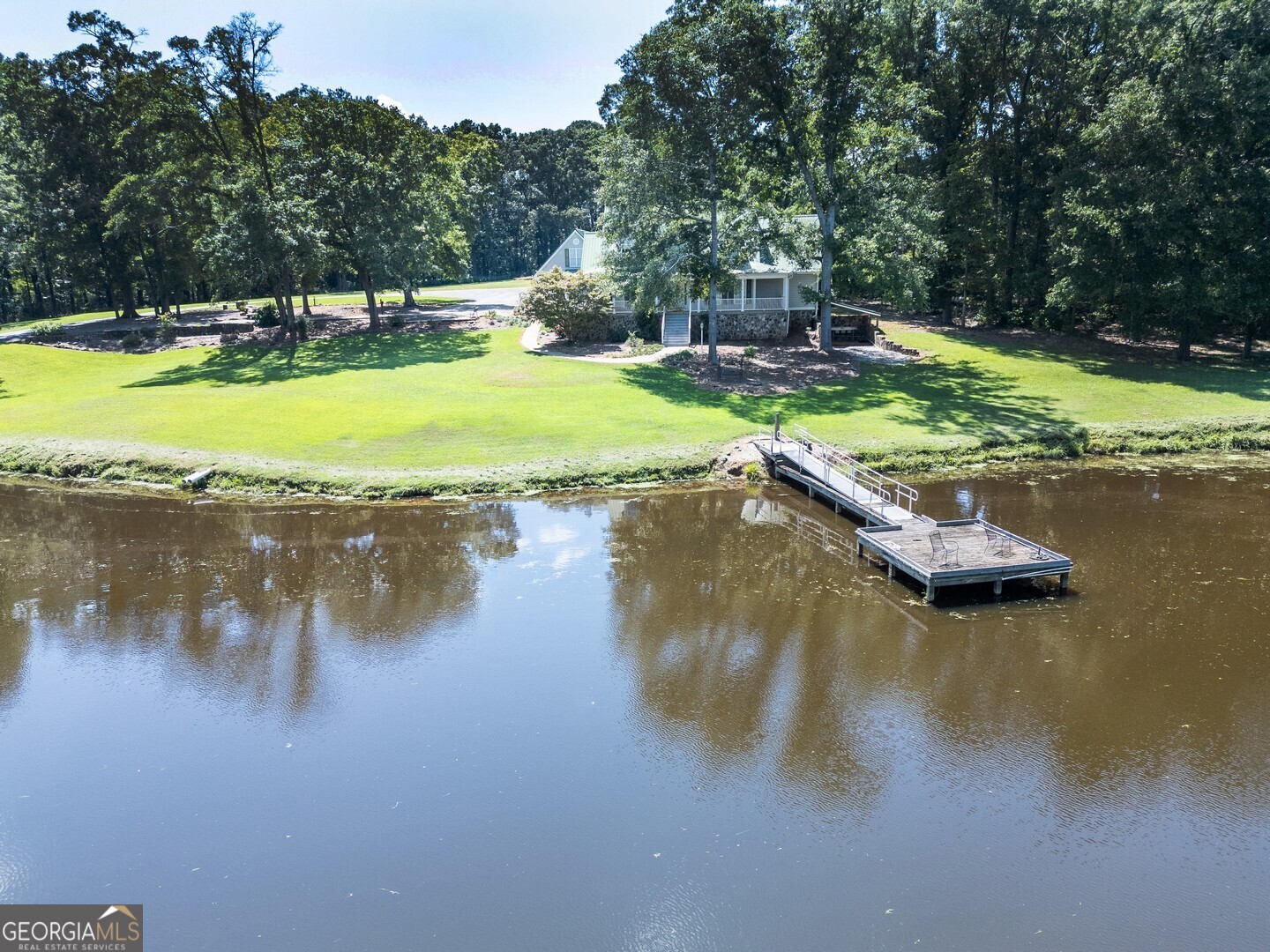 925 Highway 36 East Jackson, GA 30233 - Photo 67 of 90 a view of a lake with lawn chairs and large trees