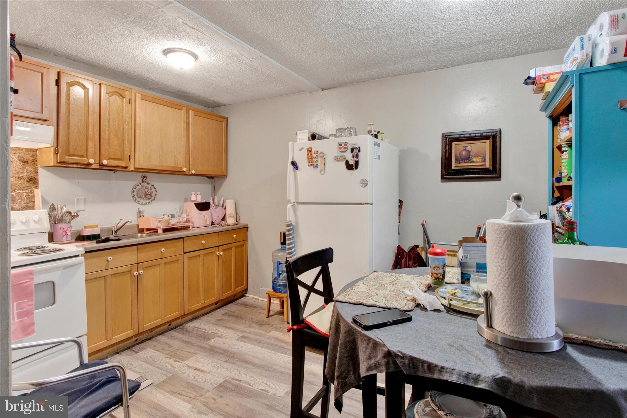 238 South 5th Street Reading, PA 19602 - Photo 14 of 28 a kitchen with stainless steel appliances granite countertop a stove top oven a refrigerator a dining table and chairs with wooden floor