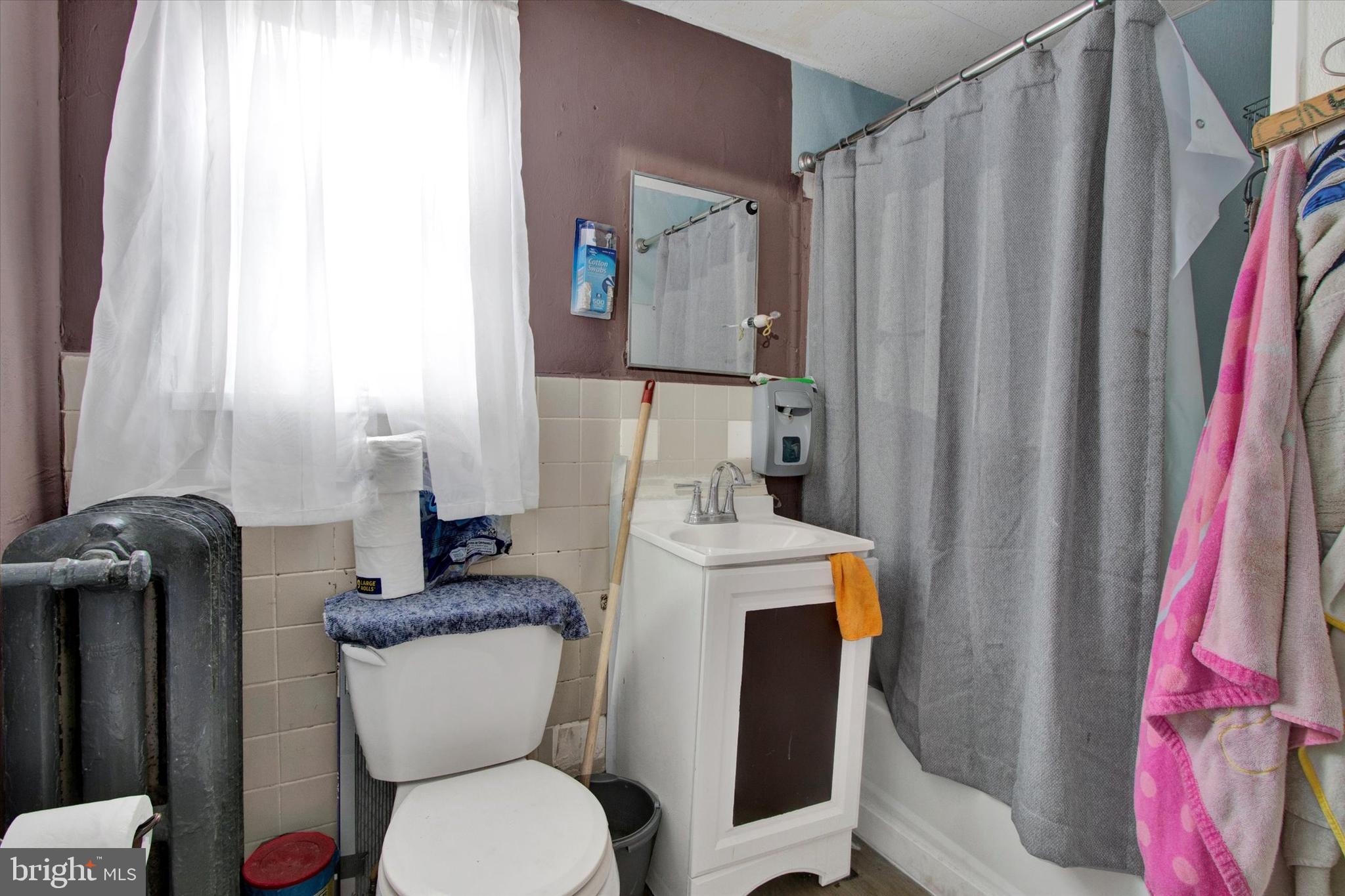 238 South 5th Street Reading, PA 19602 - Photo 5 of 28 a white toilet sitting next to a shower curtain