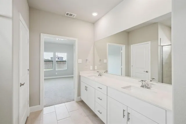 a spacious bathroom with a double vanity sink mirror and