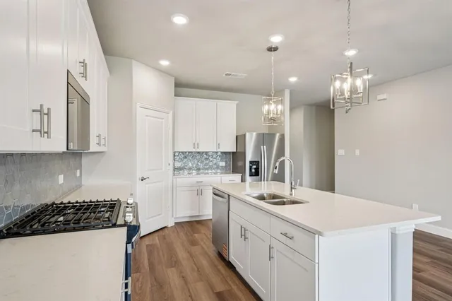 a kitchen with kitchen island white cabinets and refrigerator