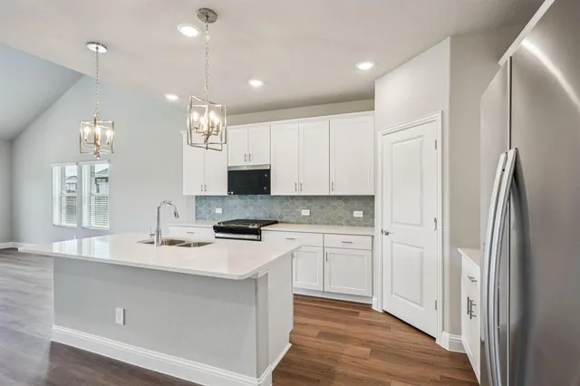 a kitchen with kitchen island a sink stainless steel appliances and cabinets