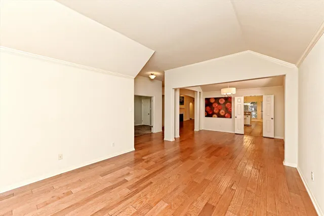 a view of an empty room with wooden floor