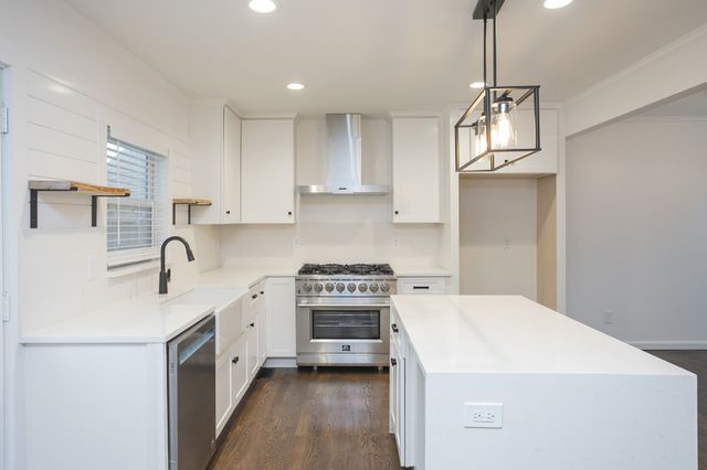 a kitchen with a sink a stove and cabinets