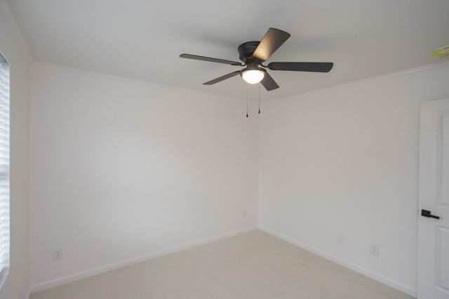 an empty room with a window and a ceiling fan