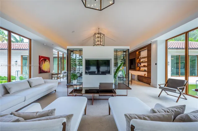 a living room with furniture kitchen view and a flat screen tv