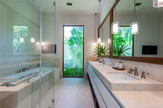 a bathroom with a double vanity sink a mirror and a shower