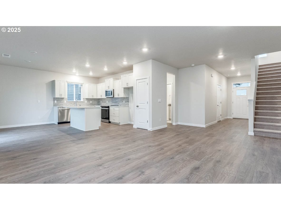 9355 Southeast Crystal Rose Street Happy Valley, OR 97086 - Photo 7 of 27 a room with stainless steel appliances kitchen island sink refrigerator and window
