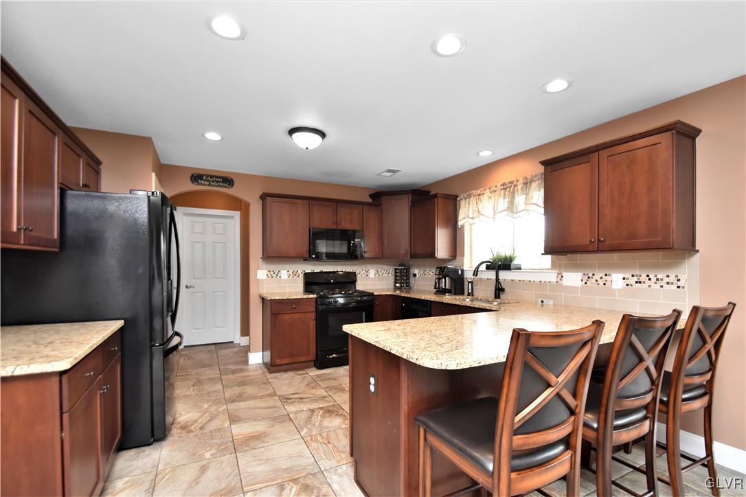 249 East Dell Road Bath, PA 18014 - Photo 21 of 50 a kitchen with stainless steel appliances granite countertop a sink a stove a refrigerator cabinets and chairs