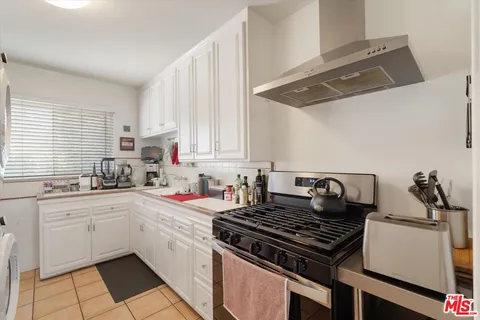 a kitchen with a stove a sink and cabinets