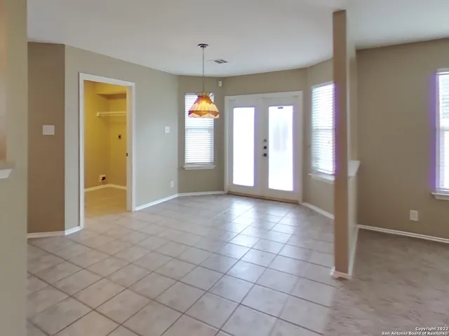 a view of an empty room with window and bathroom
