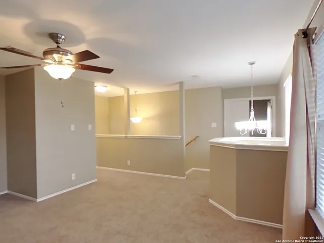 a view of a kitchen with a sink and chandelier fan
