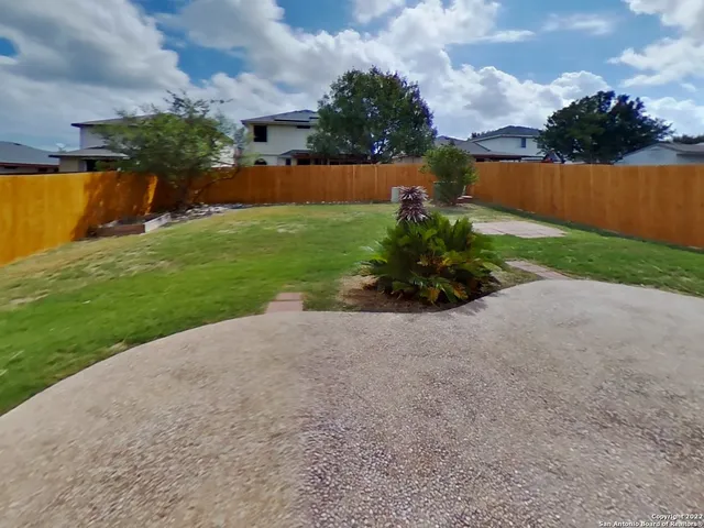 a front view of a house with a yard and potted plants