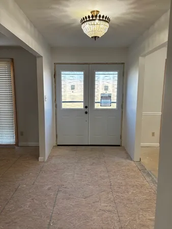 an empty room with windows and entrance