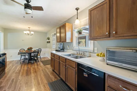 a kitchen with a sink a counter space appliances and cabinets