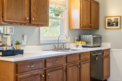 a kitchen with stainless steel appliances granite countertop a sink a stove and cabinets