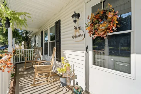 a view of a porch with a table and chairs and potted plants