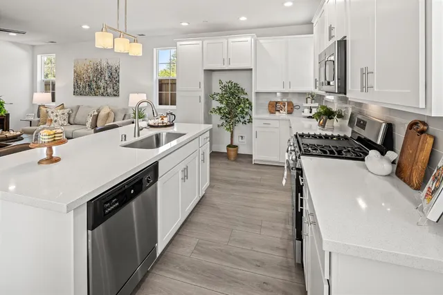 a kitchen with a sink a stove and cabinets