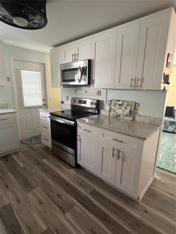 2295 North Beach Road, Unit 23 Englewood, FL 34223 - Photo 6 of 20 a kitchen with stainless steel appliances granite countertop a sink a stove a microwave and cabinets
