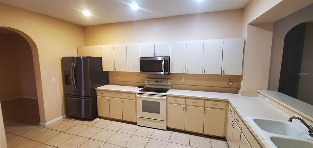 810 Terranova Road Winter Haven, FL 33884 - Photo 3 of 10 a kitchen with a stove microwave and refrigerator