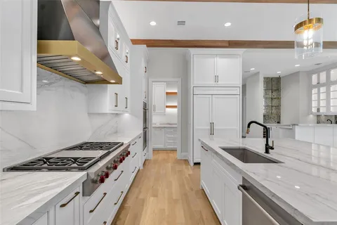 a kitchen with granite countertop a sink stainless steel appliances and cabinets