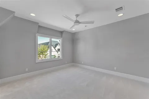 an empty room with windows and ceiling fan