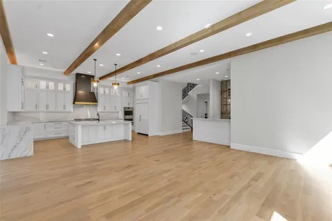 a view of kitchen with white cabinets and wooden floor