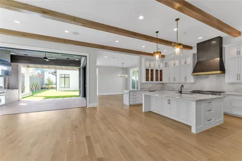 a large kitchen with stainless steel appliances a large counter top a stove and a sink