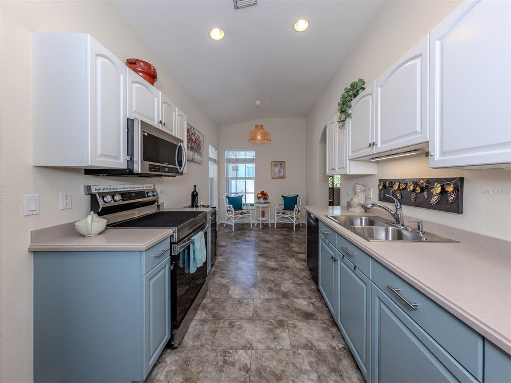 205 Reclinata Circle Venice, FL 34292 - Photo 18 of 62 a kitchen with kitchen island granite countertop a sink a counter top space appliances and cabinets