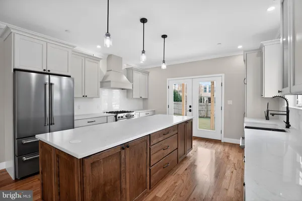 a kitchen with kitchen island a counter top space a sink stainless steel appliances and cabinets