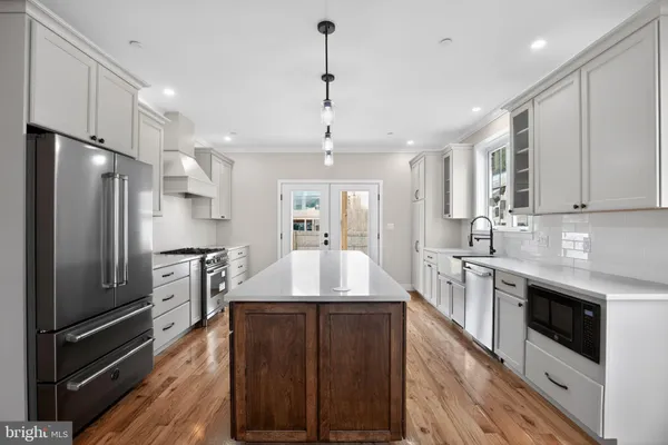 a large kitchen with granite countertop a large counter top appliances and cabinets